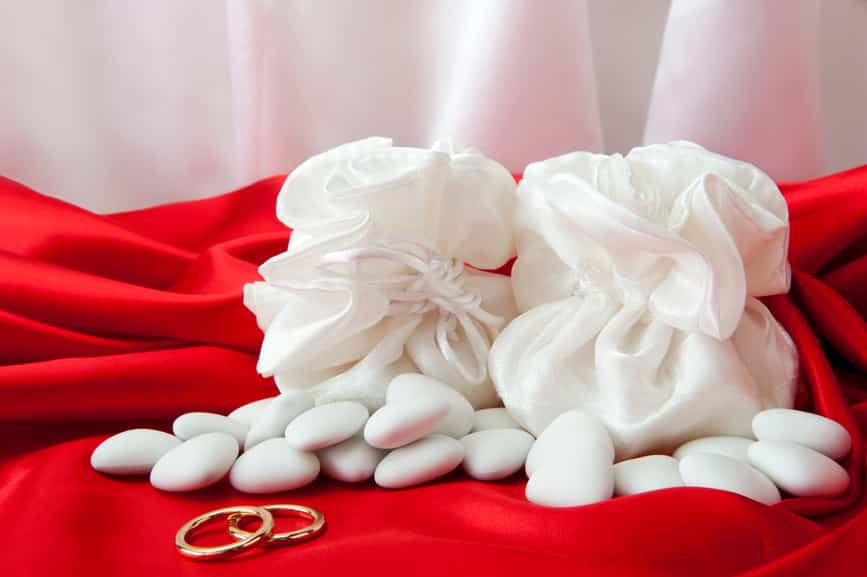 wedding rings and favors on elegant fabric